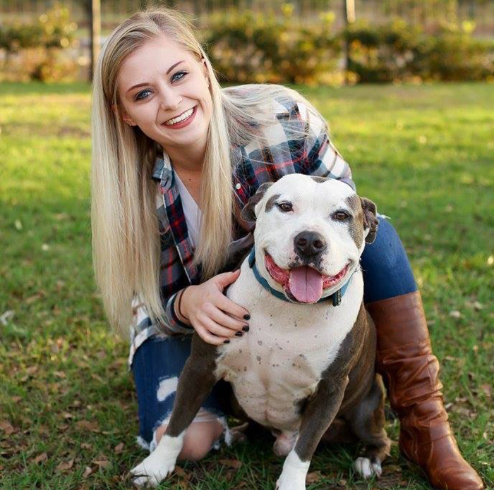 Woman sitting behind her brown and white dog