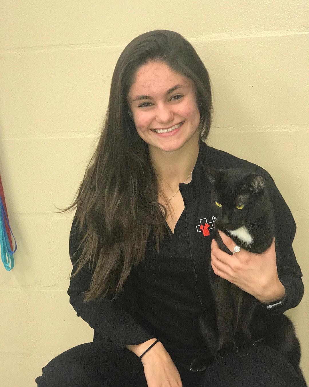 Woman holding a black and white cat