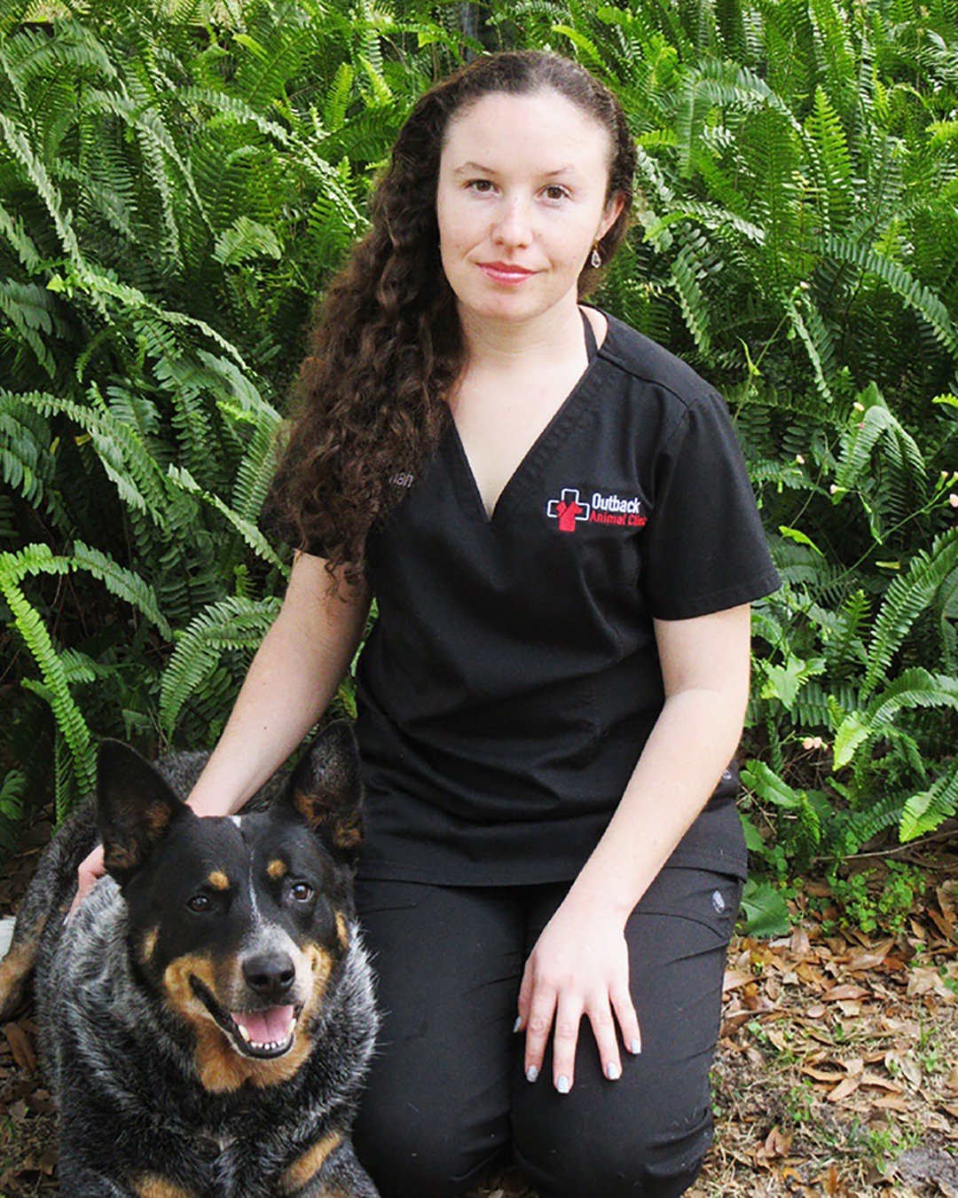 Woman sitting next to her blue heeler dog